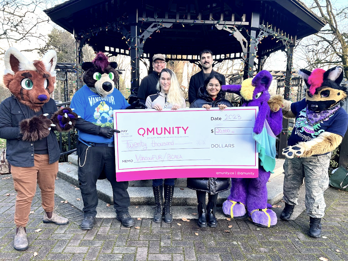 A photo of the VancouFur charity team presenting a giant cheque to Qmunity